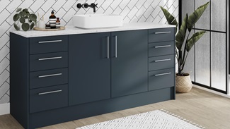 Nautical bathroom idea with marine-blue slab cupboard doors and white worktops. Includes silver bar handles and oak flooring.