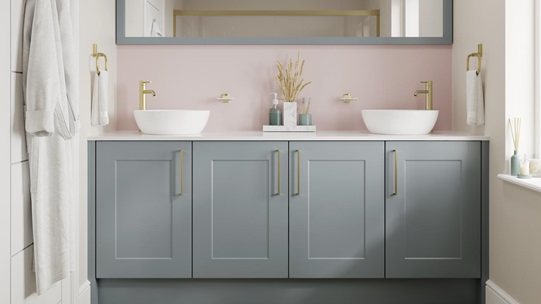 Small shaker bathroom with dusk-blue cupboard doors. Has a white worktop, oak floors, and brass handles for a luxe touch.