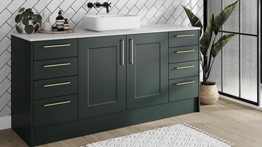 Compact green bathroom featuring shaker cupboards with a matt finish. Has brass handles, a white worktop, and an oak floor.